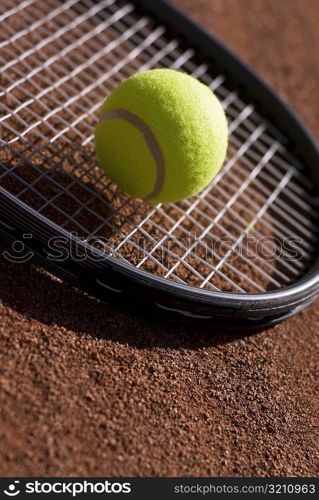 Close-up of a tennis ball on a racket in a court