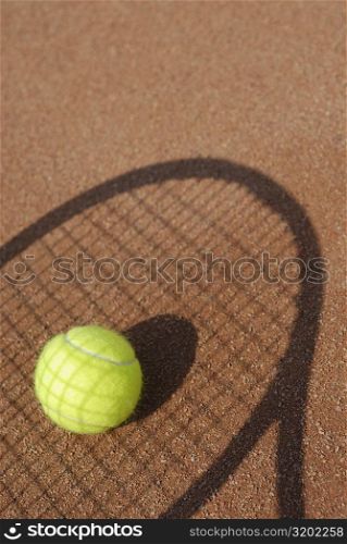 Close-up of a tennis ball on the shadow of a tennis racket