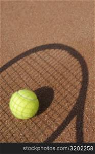 Close-up of a tennis ball on the shadow of a tennis racket