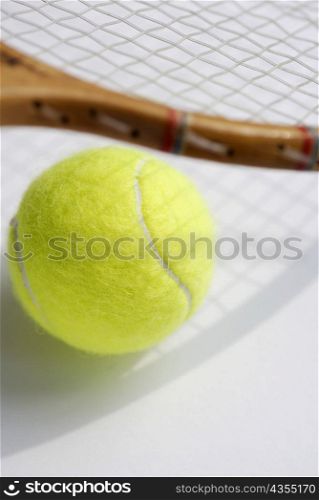 Close-up of a tennis ball with a tennis racket