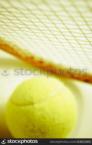 Close-up of a tennis ball with a tennis racket