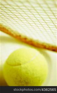 Close-up of a tennis ball with a tennis racket