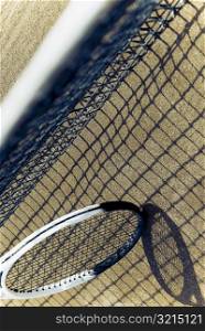 Close-up of a tennis net with a tennis racket