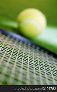 Close-up of a tennis racket and a tennis ball