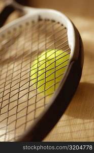 Close-up of a tennis racket and a tennis ball