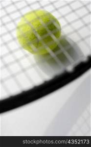 Close-up of a tennis racket on a tennis ball