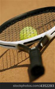 Close-up of a tennis racket on a tennis ball