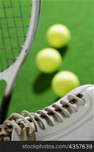 Close-up of a tennis shoe with a tennis racket