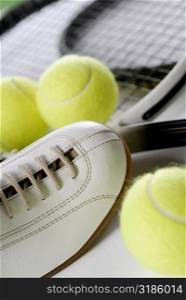 Close-up of a tennis shoe with tennis balls and rackets