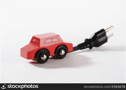 Close-up of a toy electric car with an electric plug