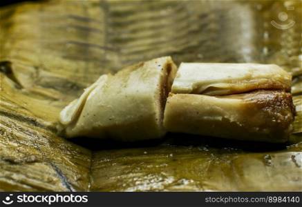 Close up of a traditional tamale on a banana leaf. Nicaraguan pisque tamale on banana leaf. Tamalpisque traditional Central American food, Stuffed tamale served in banana leaves.