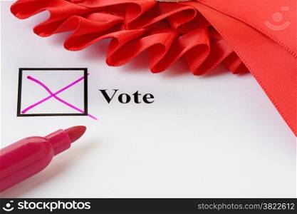 Close up of a vote cast on a ballot paper. Cross with pen and election rosette.