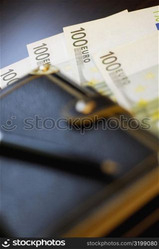 Close-up of a wallet on one hundred Euro banknotes