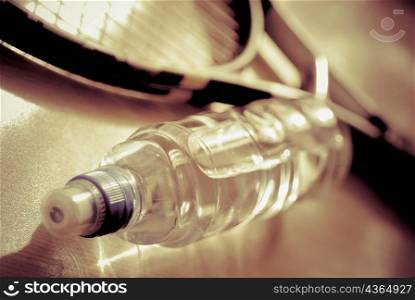 Close-up of a water bottle with a tennis racket