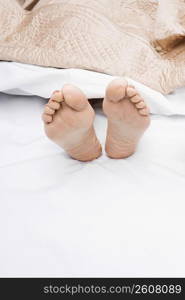 Close-up of a woman&acute;s feet on the bed