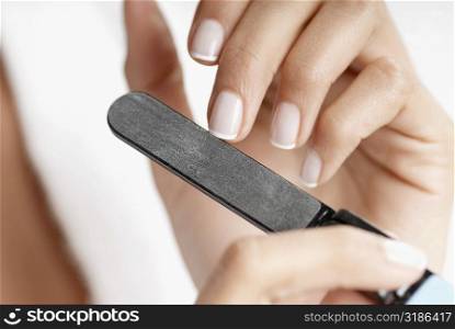 Close-up of a woman&acute;s hand filing her nails