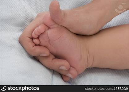 Close-up of a woman&acute;s hand holding a baby&acute;s foot