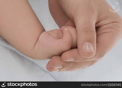 Close-up of a woman&acute;s hand holding a baby hand