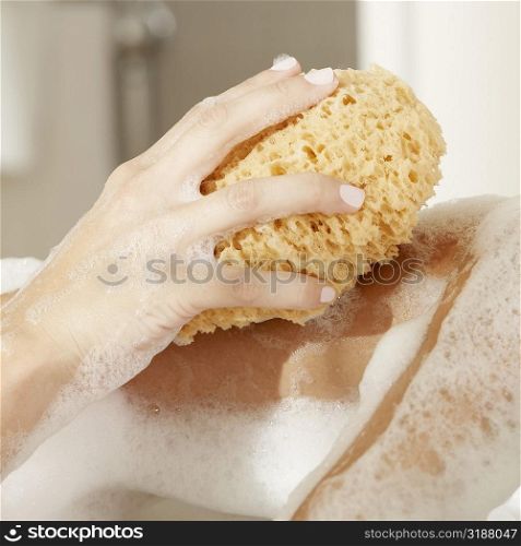 Close-up of a woman&acute;s hand holding a bath sponge