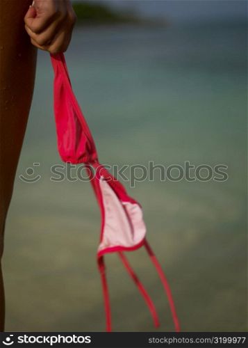 Close-up of a woman&acute;s hand holding a bikini top