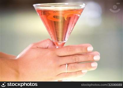 Close-up of a woman&acute;s hand holding a glass of martini