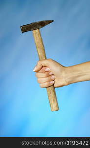 Close-up of a woman&acute;s hand holding a hammer