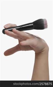 Close-up of a woman&acute;s hand holding a make-up brush