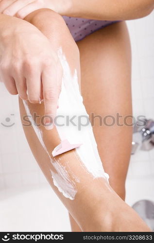 Close-up of a woman&acute;s hand shaving her leg