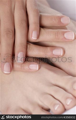 Close-up of a woman&acute;s hand touching her feet