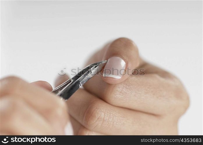 Close-up of a woman&acute;s hand using a nail scissor