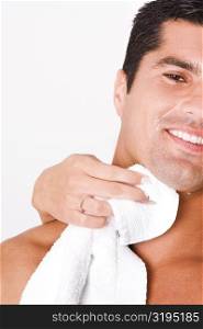Close-up of a woman&acute;s hand wiping a mid adult man&acute;s face with a towel