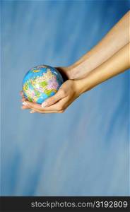 Close-up of a woman&acute;s hands holding a globe