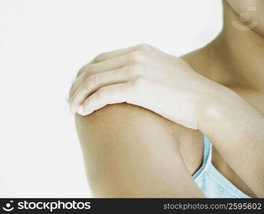 Close-up of a woman applying moisturizer on her shoulder