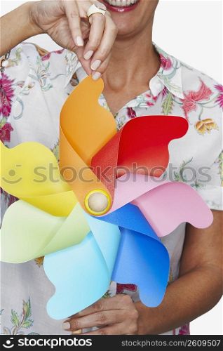 Close-up of a woman holding a pinwheel and smiling