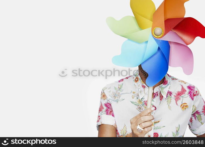 Close-up of a woman holding a pinwheel in front of her face