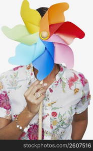 Close-up of a woman holding a pinwheel in front of her face