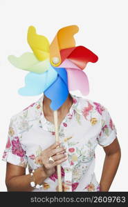 Close-up of a woman holding a pinwheel in front of her face