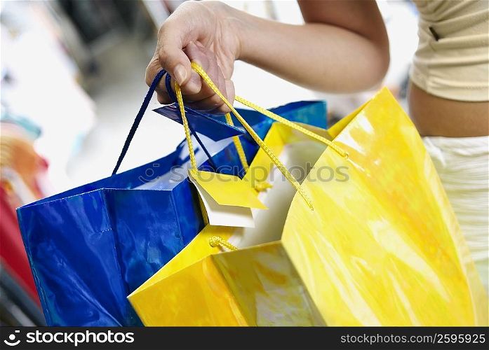 Close-up of a woman holding shopping bags
