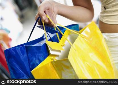 Close-up of a woman holding shopping bags