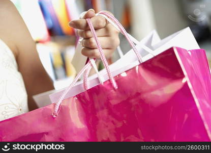 Close-up of a woman holding shopping bags