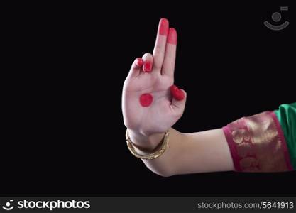 Close-up of a woman&rsquo;s hand making a Bharatanatyam gesture called Ardhapataka on black background