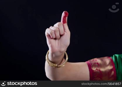 Close-up of a woman&rsquo;s hand making a Bharatanatyam gesture called Kapitta on black background