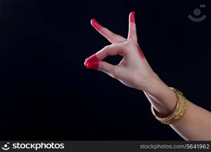 Close-up of a woman&rsquo;s hand making a Bharatanatyam gesture called Katakamukha on black background