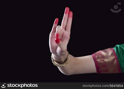Close-up of a woman&rsquo;s hand making a Bharatanatyam gesture called Mayura on black background