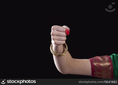 Close-up of a woman&rsquo;s hand making a Bharatanatyam gesture called Mushthi on black background