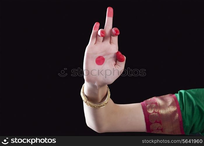 Close-up of a woman&rsquo;s hand making a Bharatanatyam gesture called Shukatunda on black background