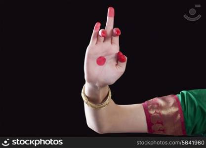 Close-up of a woman&rsquo;s hand making a Bharatanatyam gesture called Shukatunda on black background