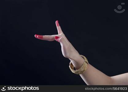 Close-up of a woman&rsquo;s hand making Bharatanatyam gesture called Hamsapaksha on black background