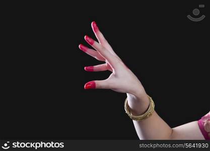 Close-up of a woman&rsquo;s hand making Bharatanatyam gesture called Sandamsha on black background