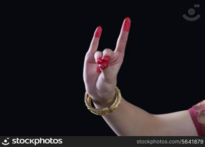 Close-up of a woman&rsquo;s hand making Bharatanatyam gesture called Simhamukha on black background